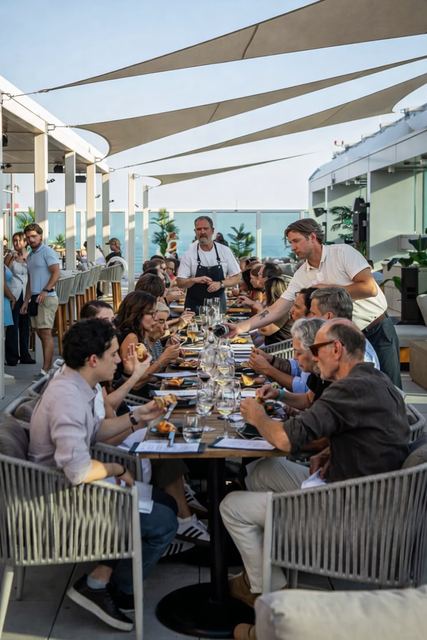 A long table of guests under the Aera shade sails
