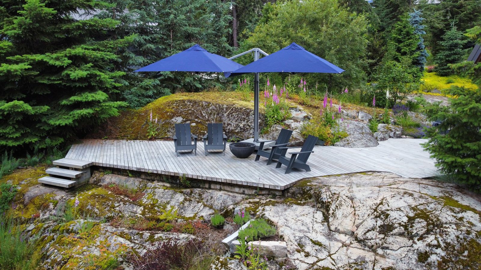 Shadowspec Unity Duo umbrellas over a cedar deck among the trees and rock at a chalet in Whistler, British Columbia